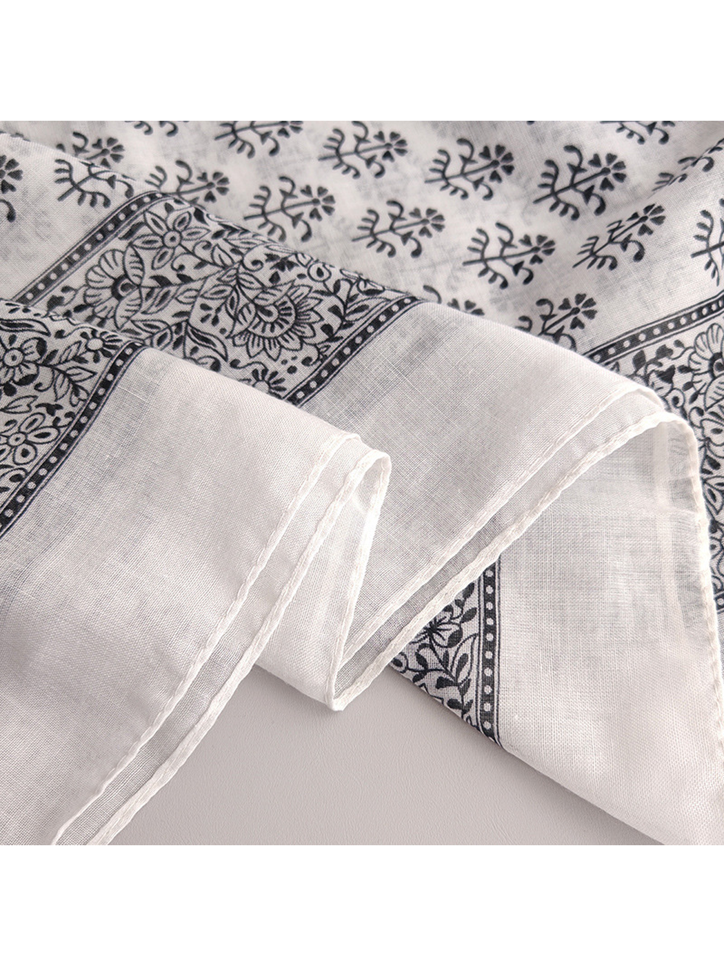 Close-up of the scarf's stitched edge and floral border