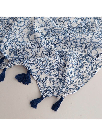 Close-up of the navy floral pattern and tassel-trimmed edge