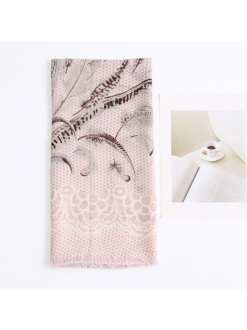 Folded light pink scarf displaying the feather motif and fringed edge