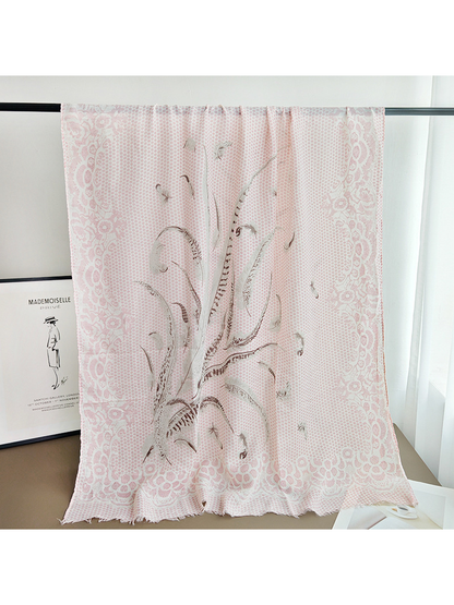 Long light pink patterned scarf draped over a display rail