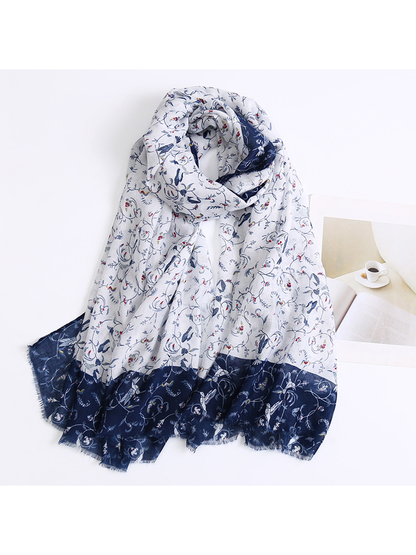 Ivory and navy floral-and-bird scarf draped with a fringed border