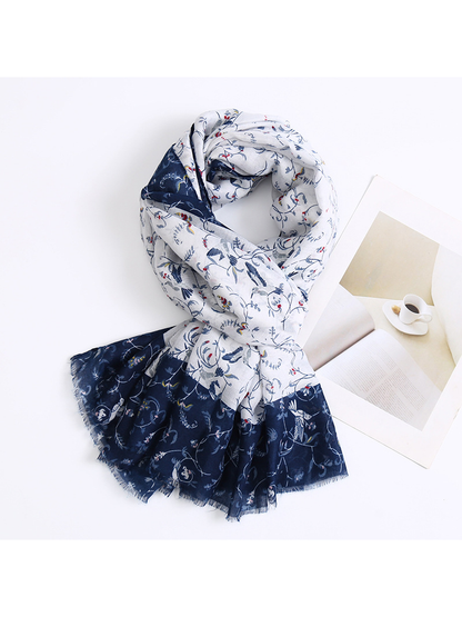 Ivory and navy floral-and-bird scarf arranged in a loose knot