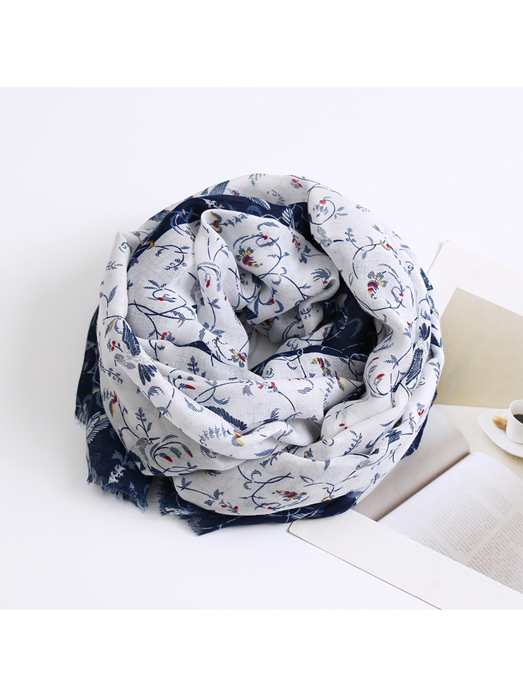 Ivory and navy patterned scarf arranged in a compact roll
