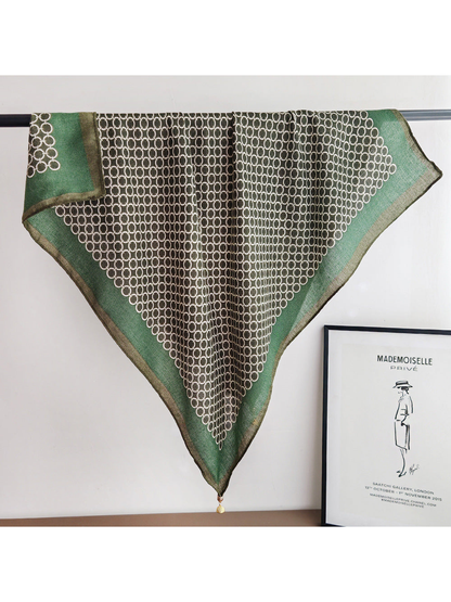 Green square scarf with an interlocking ring pattern, full draped view