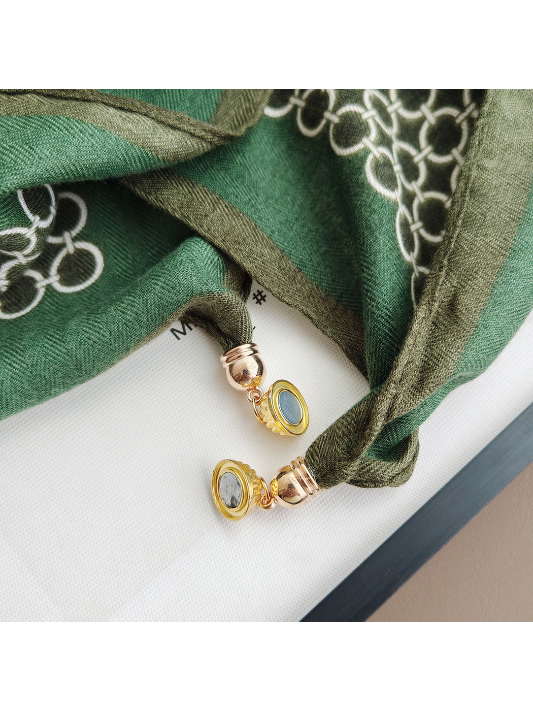 Close-up of the scarf's gold-tone circular end ornaments