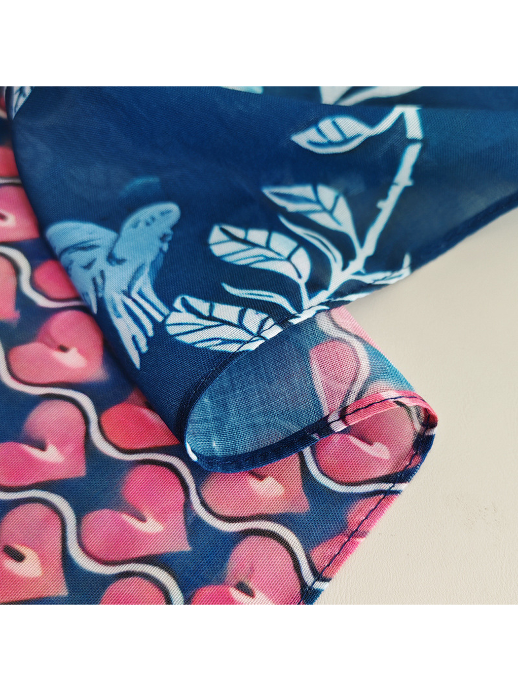 Close-up of the scarf's narrow stitched edge and heart pattern