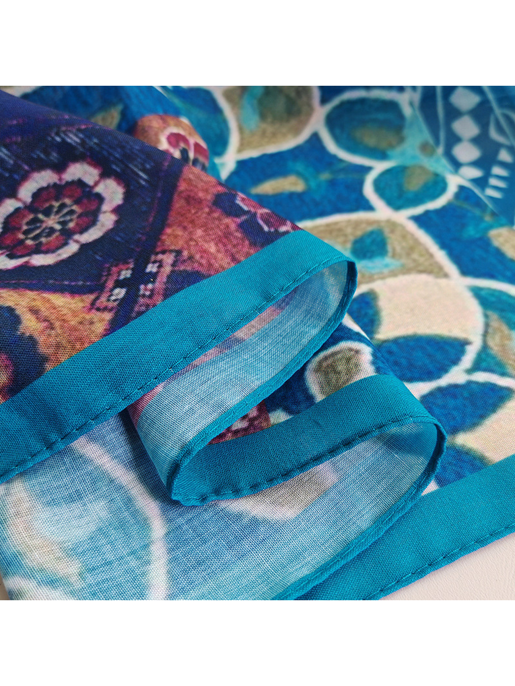 Close-up of the scarf's turquoise bound edge and visible stitching