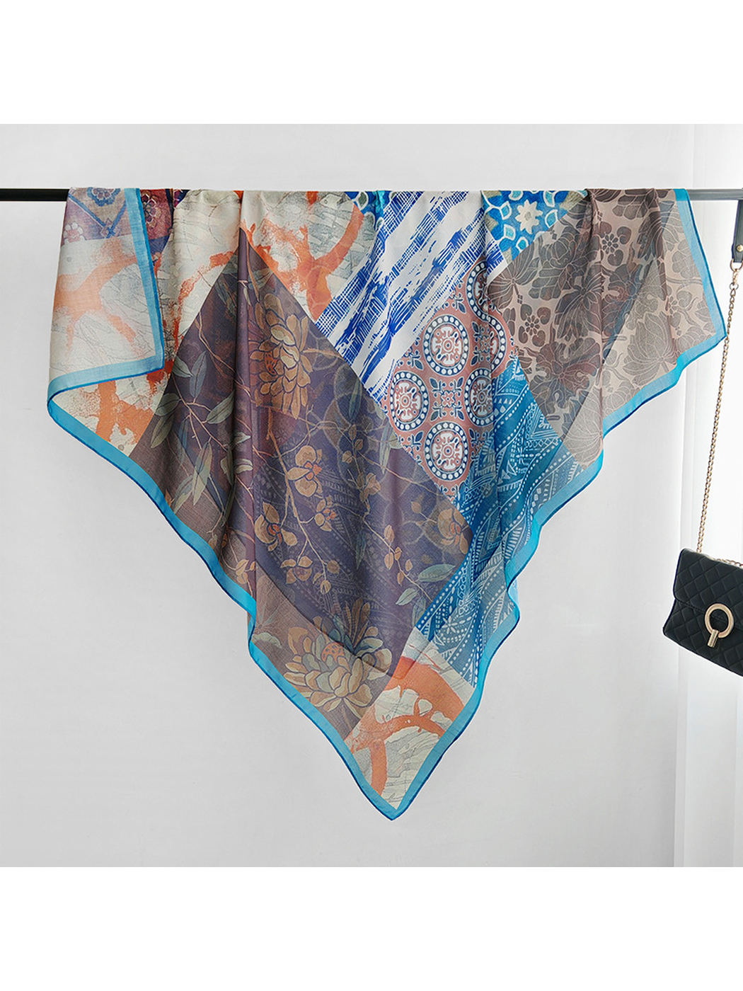 Multicolor patchwork square scarf draped open over a rail
