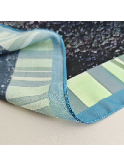 Close-up of the scarf's narrow stitched blue edge and striped border