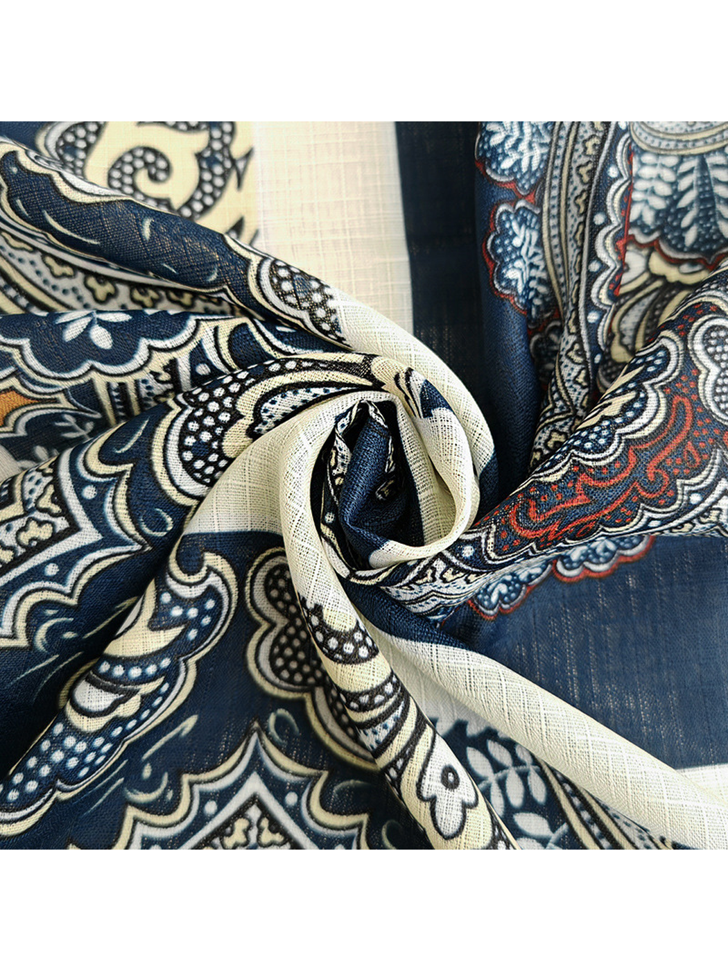 Close-up of the scarf's navy, ivory and orange ornamental pattern in soft folds