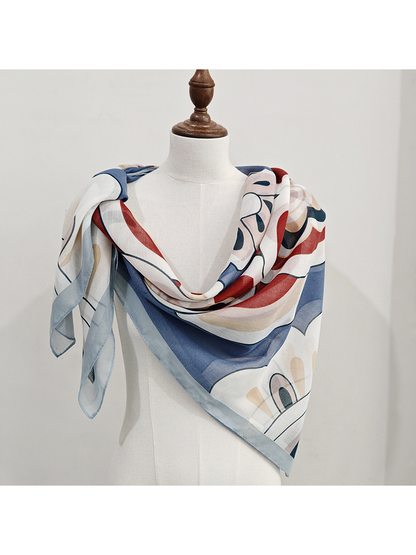 Light blue patterned square scarf draped asymmetrically on a dress form