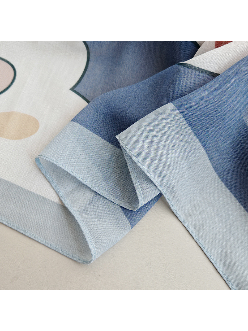 Close-up of the light blue border and neatly stitched scarf edge