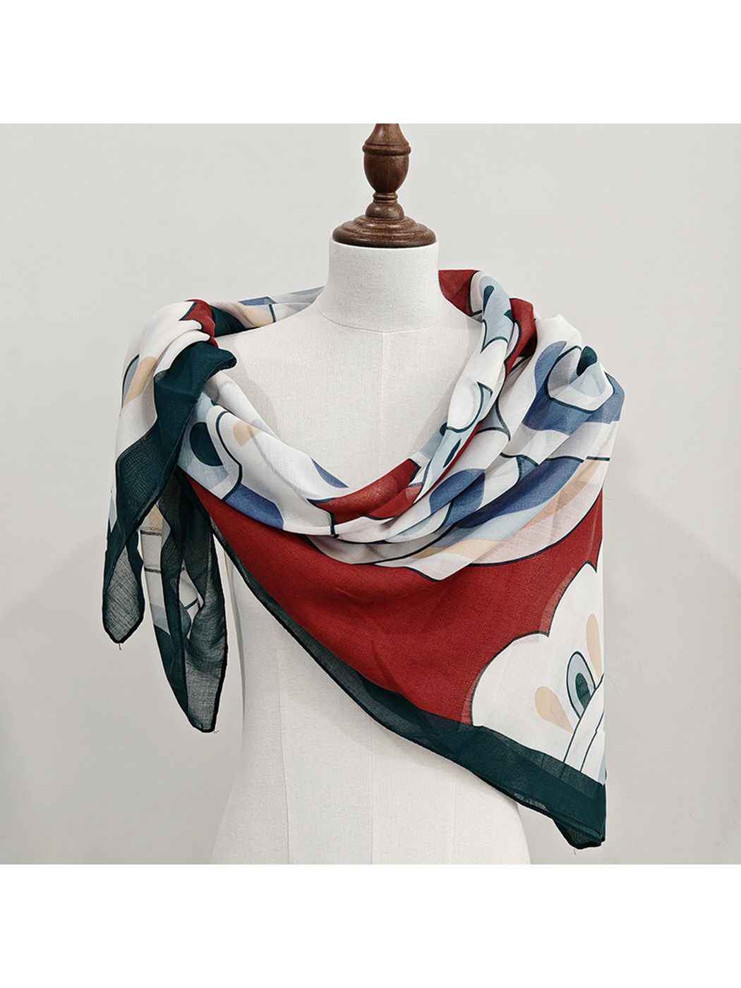 Burgundy patterned square scarf wrapped across a dress form
