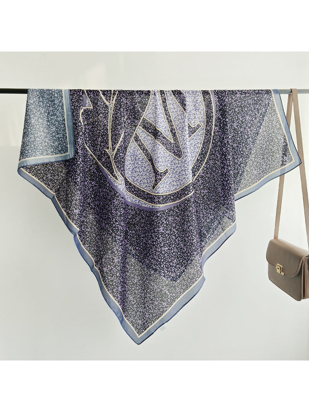 Purple and navy square scarf draped over a display rail