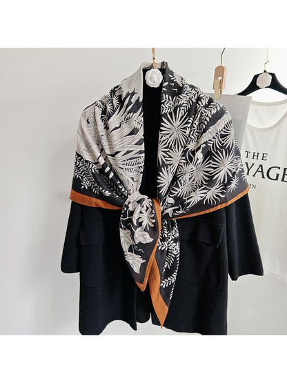 Black botanical square scarf tied over a black coat