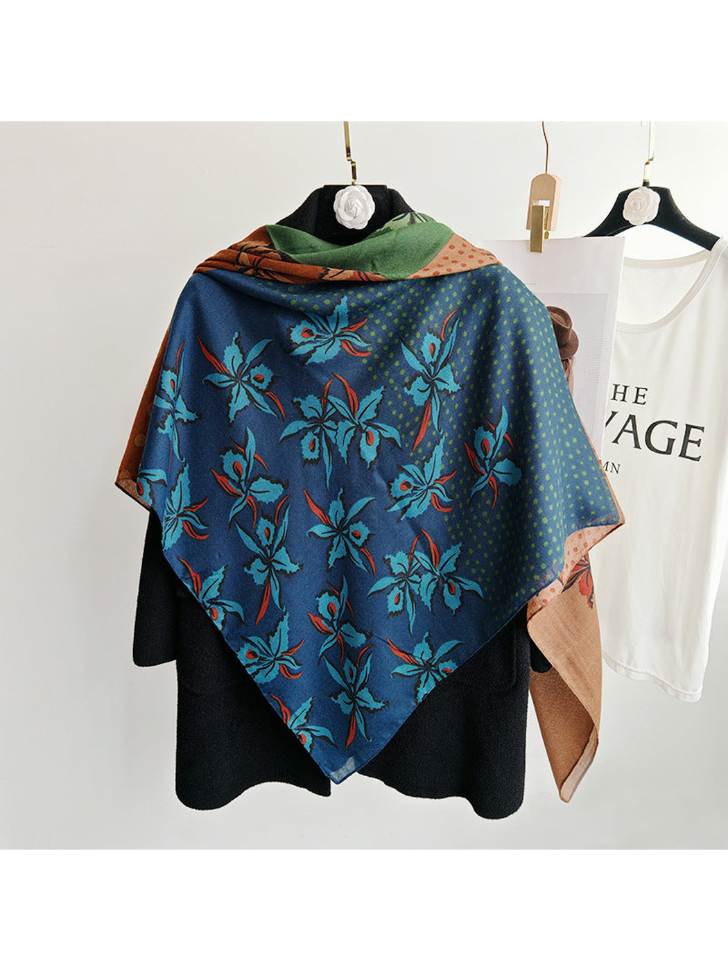 Blue floral section of a multicolor square scarf styled over a black coat