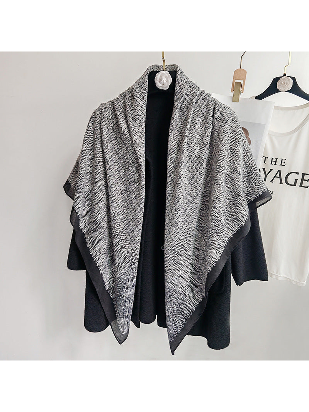 Black and gray square scarf draped loosely over a black coat