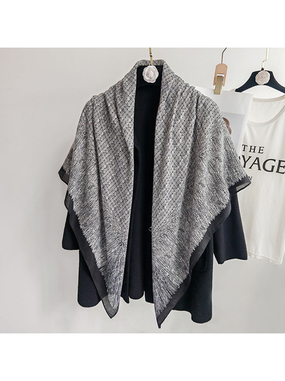 Black and gray square scarf draped loosely over a black coat