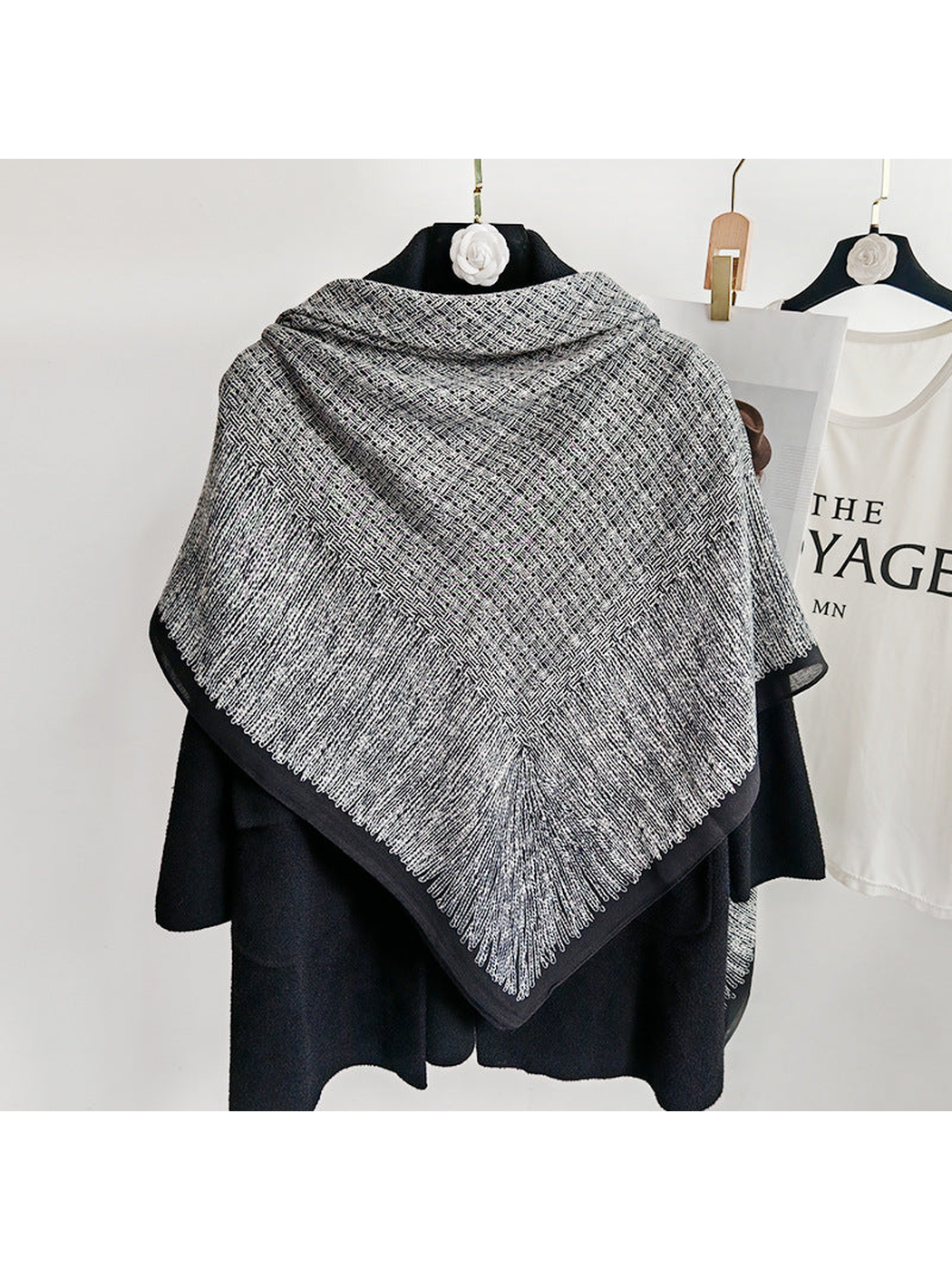 Black and gray square scarf displayed across the back of a black coat