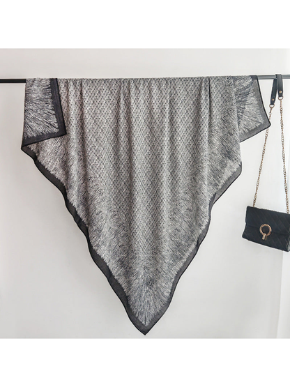 Black and gray square scarf spread over a display rail with pointed drape