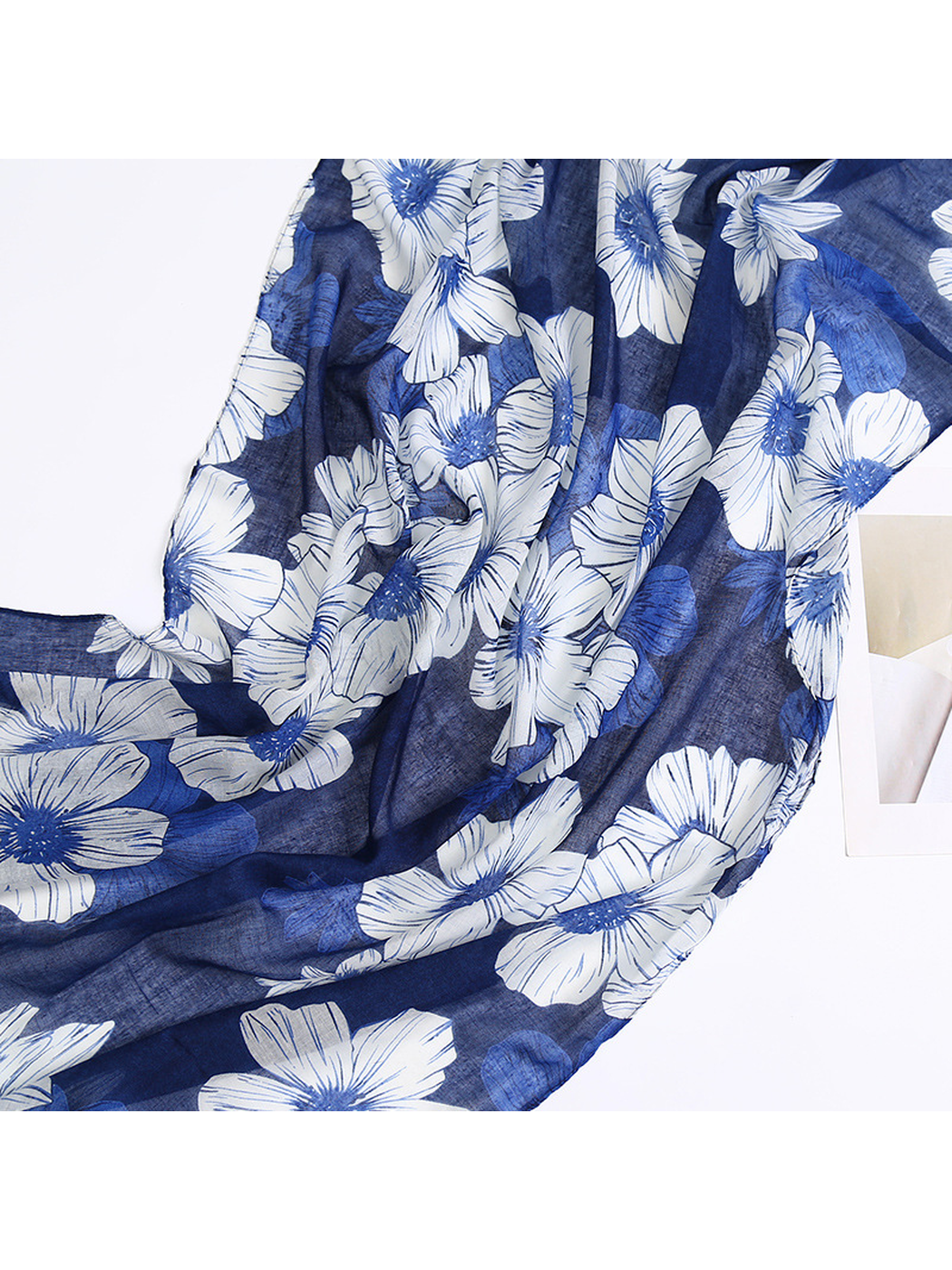 Close-up of large white and smaller blue flowers on the navy scarf