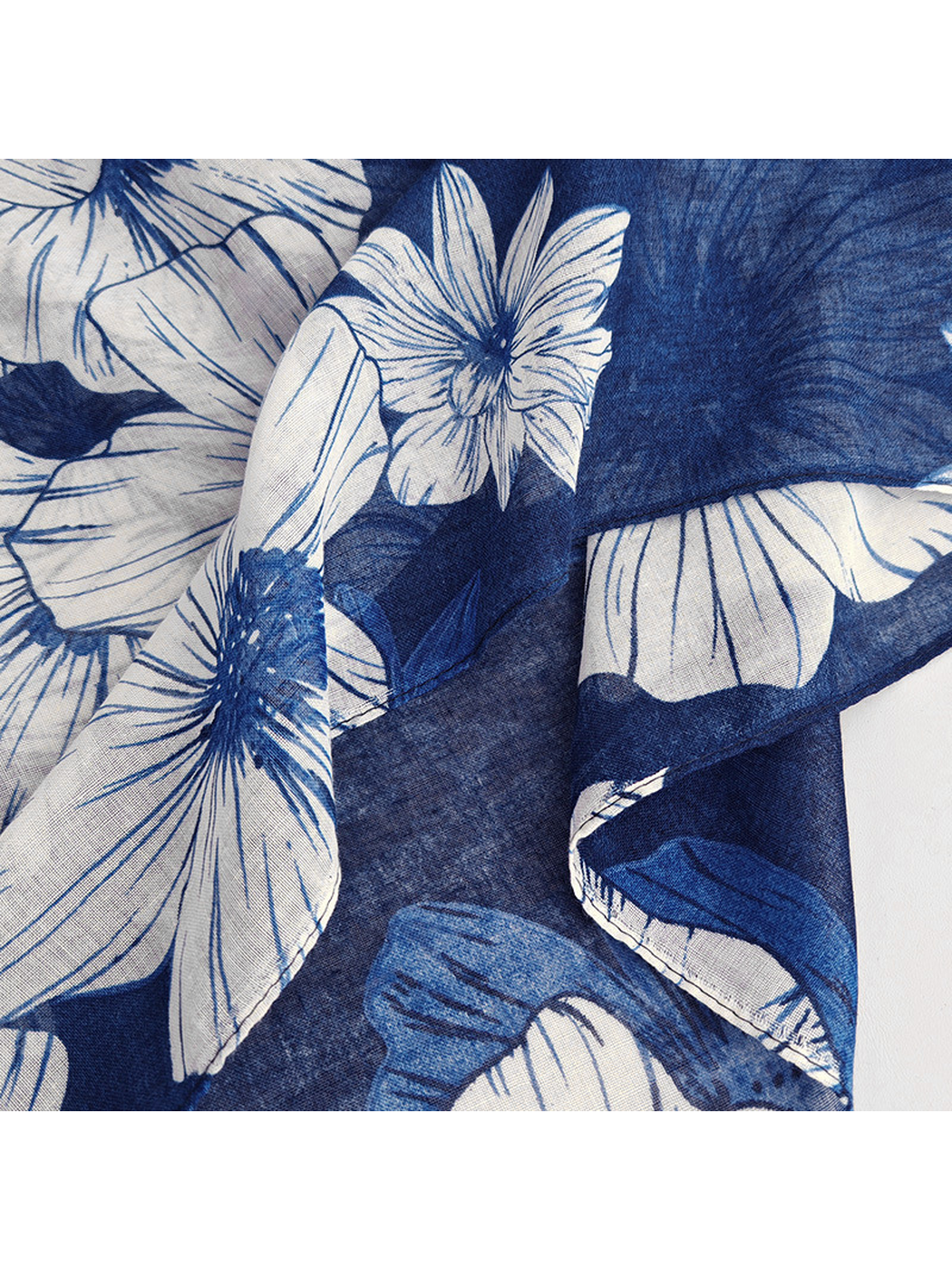 Close-up of the navy floral scarf's folded edge and print