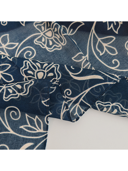 Close-up of the navy floral vine pattern and folded edge
