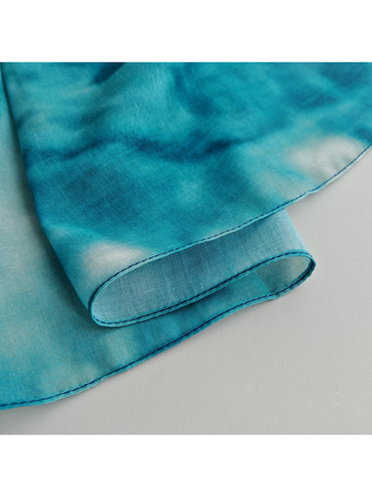 Close-up of the scarf's fine semi-sheer surface and narrow stitched edge