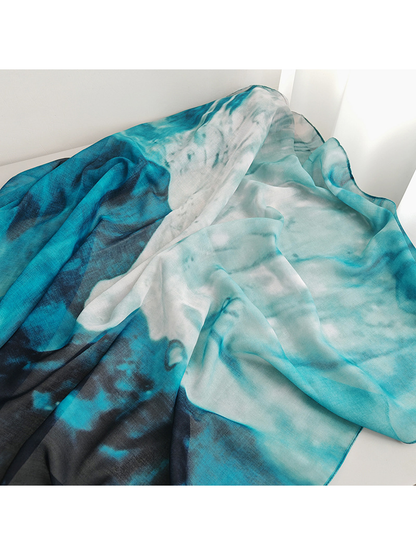Close-up of the scarf's flowing aqua, white, teal and navy color transitions