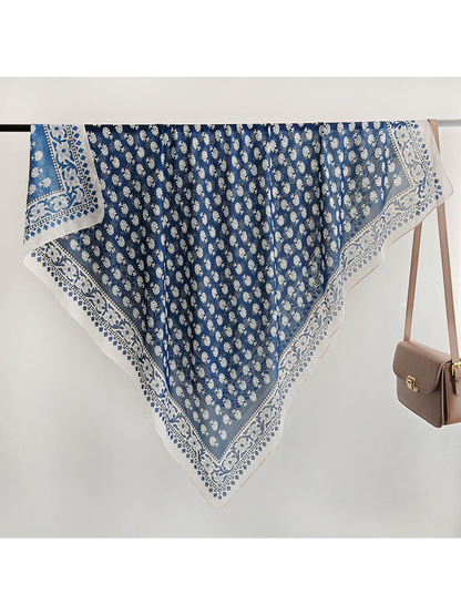 Navy and ivory square scarf spread across a display rail