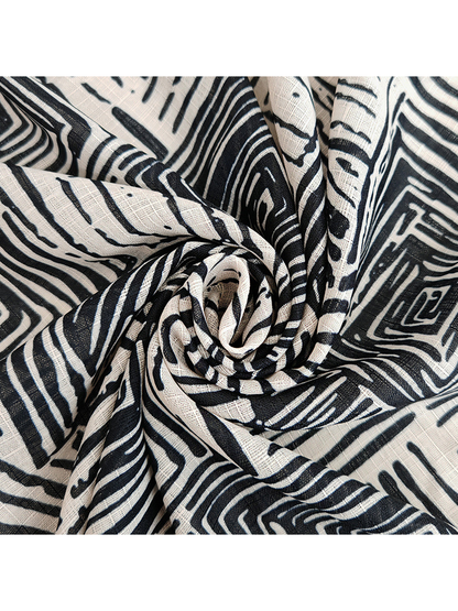 Close-up of the black and beige geometric scarf gathered into folds