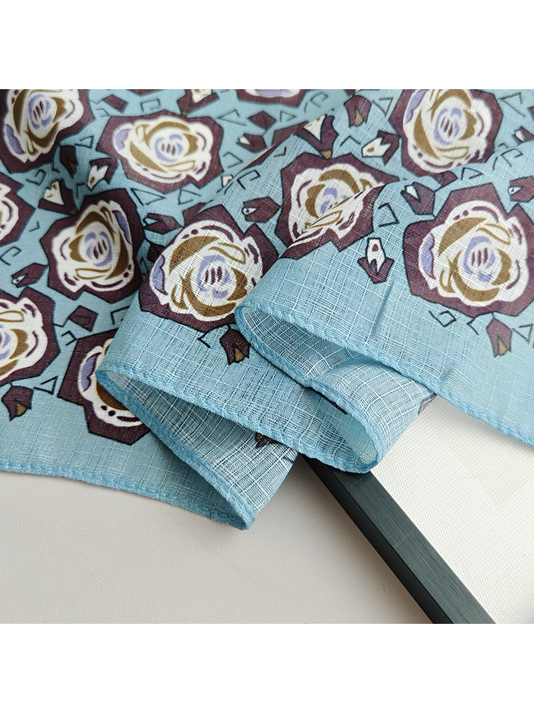 Close-up of the floral print, crosshatch texture and stitched edge