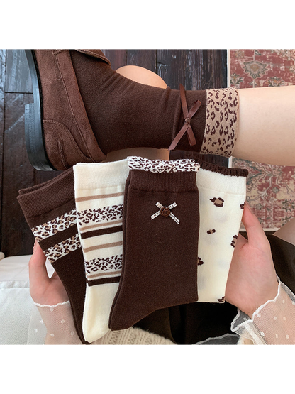 Brown and ivory patterned crew socks displayed beside a worn bow-cuff style