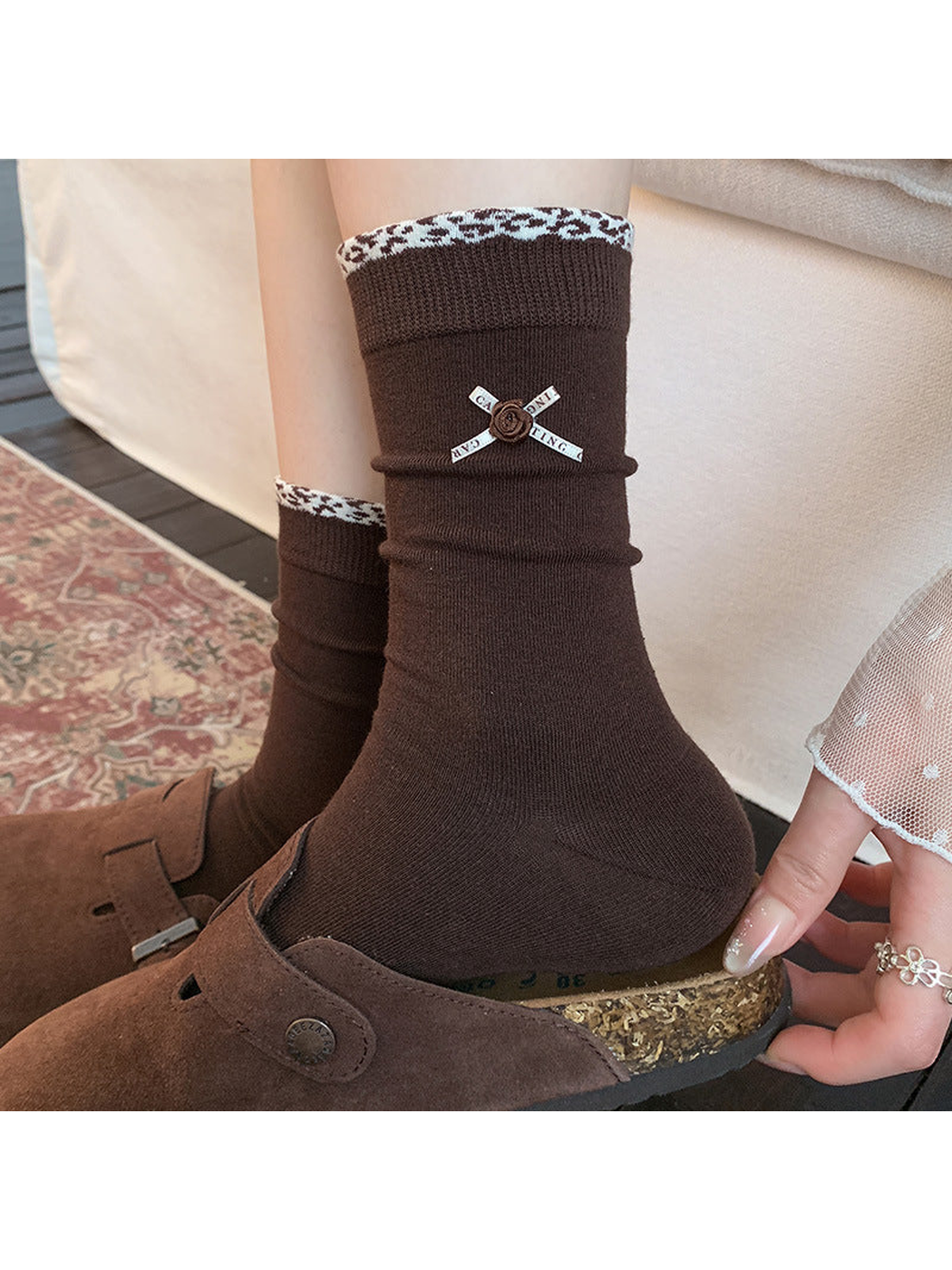Dark brown crew socks with ribbon rose accents worn with brown clogs
