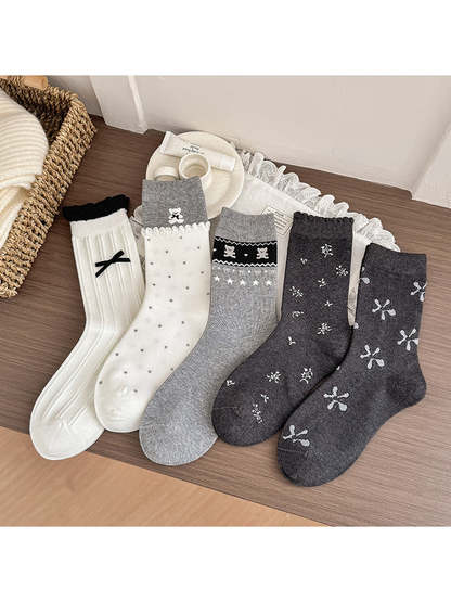 Five crew sock styles displayed together in ivory, gray and dark gray
