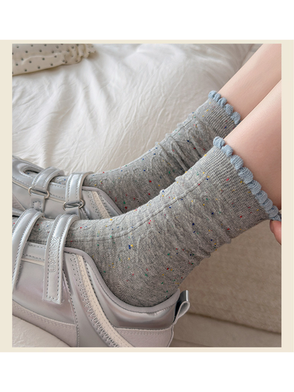 Close-up of Gray flecked socks with light blue scalloped cuffs