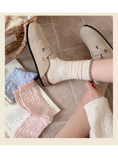 Ivory flecked cable-pattern crew socks worn with beige clogs