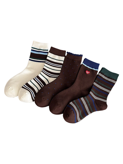 Five crew sock styles in brown, ivory, blue and green displayed together