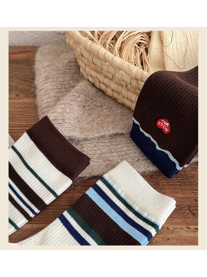 Close-up of contrasting cuffs and stripe widths across three sock styles