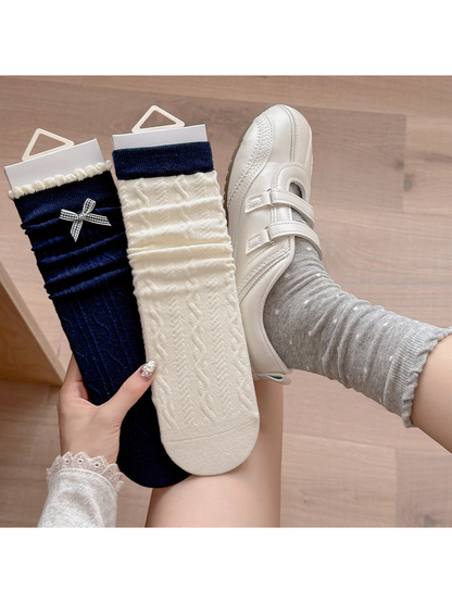 Gray Dots socks worn with white shoes beside Navy Bow and Contrast Cuff styles