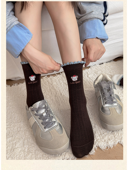 Letter Bear crew socks shown with silver-tone sneakers