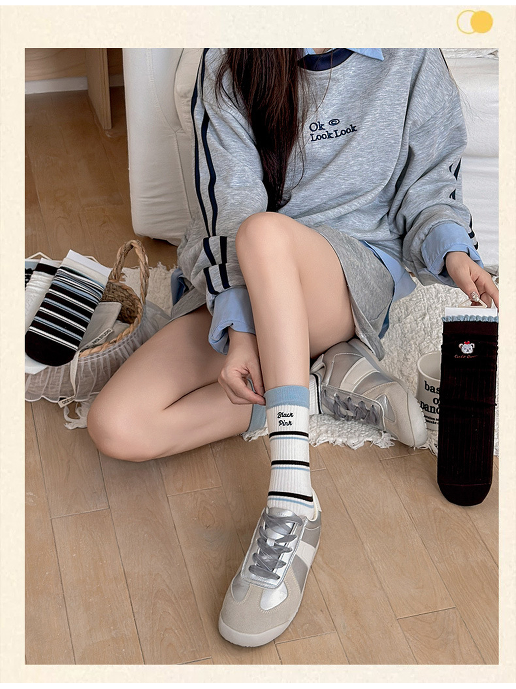 Letters crew sock styled with a silver-tone sneaker in a seated scene