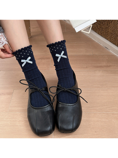 Navy Bow crew socks worn with black lace-up shoes