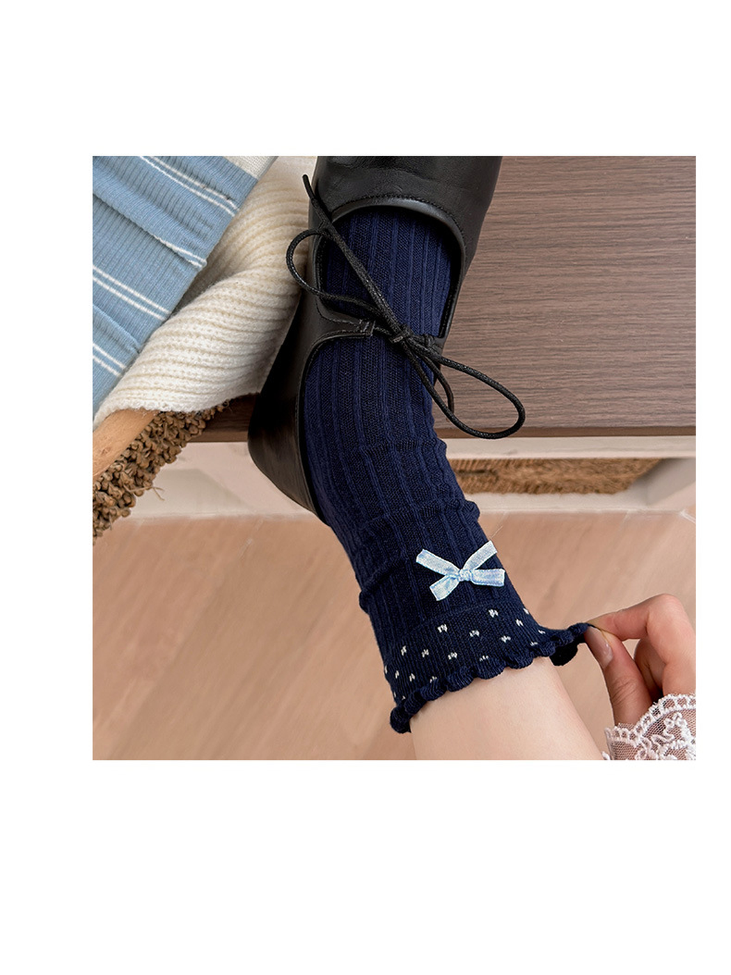 Close-up of the navy Bow sock's ribbed texture, scalloped cuff, and ribbon