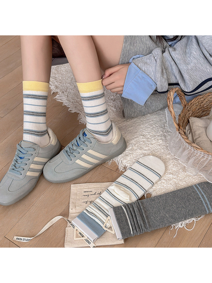 Yellow Cuff striped crew socks worn with blue sneakers
