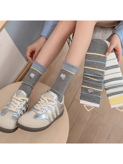 Gray Cat crew socks worn with silver-tone sneakers beside two striped styles