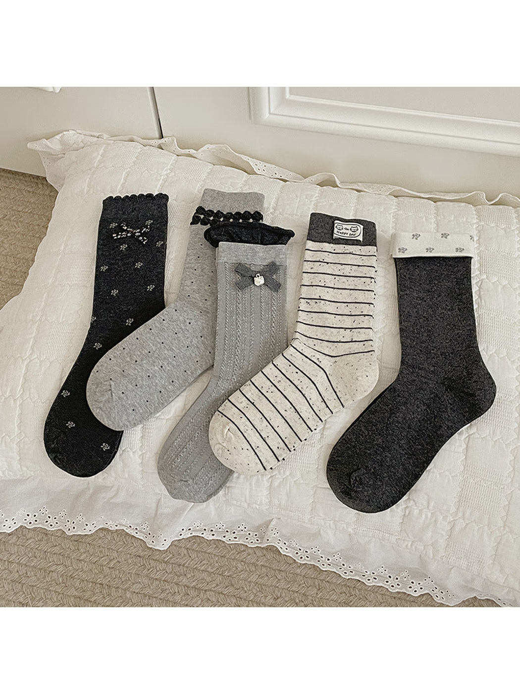 Five gray and ivory crew sock styles displayed together
