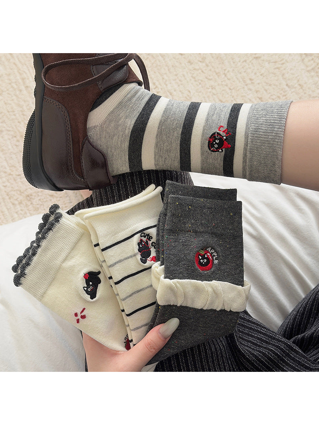 Apple Cat crew socks worn with brown sneakers beside the four sock styles