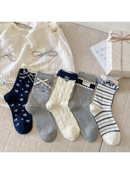 Five decorative crew sock styles in navy, gray, and ivory