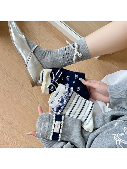 Ribbon Bow socks worn with silver flats while three other styles are held